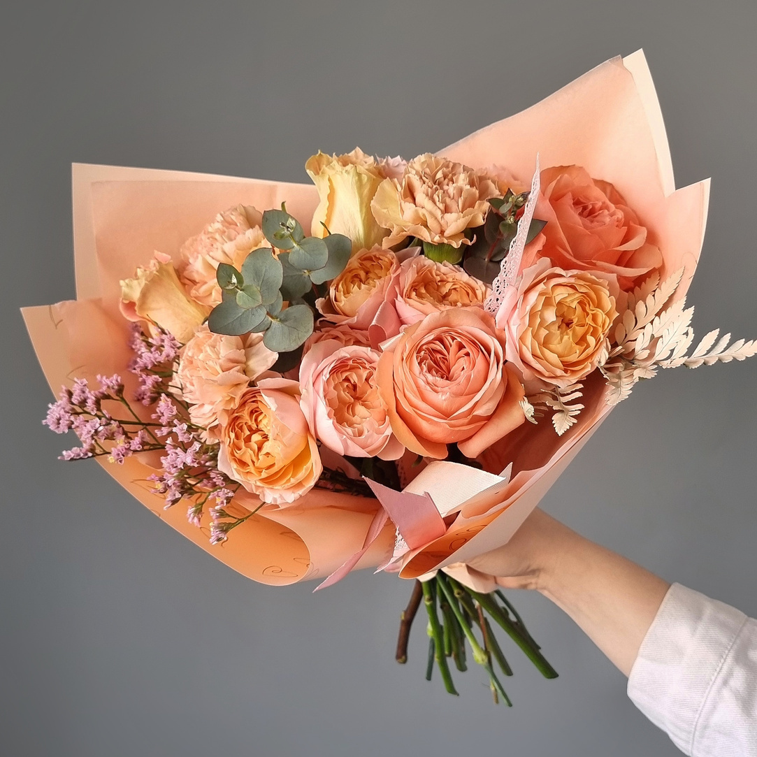 Creative roses bouquet in hand of crop florist